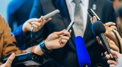 Media_holding_microphones_to_person_in_suit_.jpg
