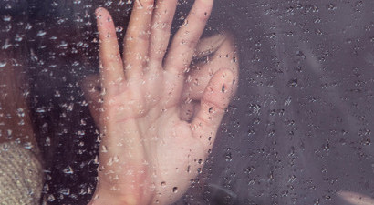 Woman behind rainy glass