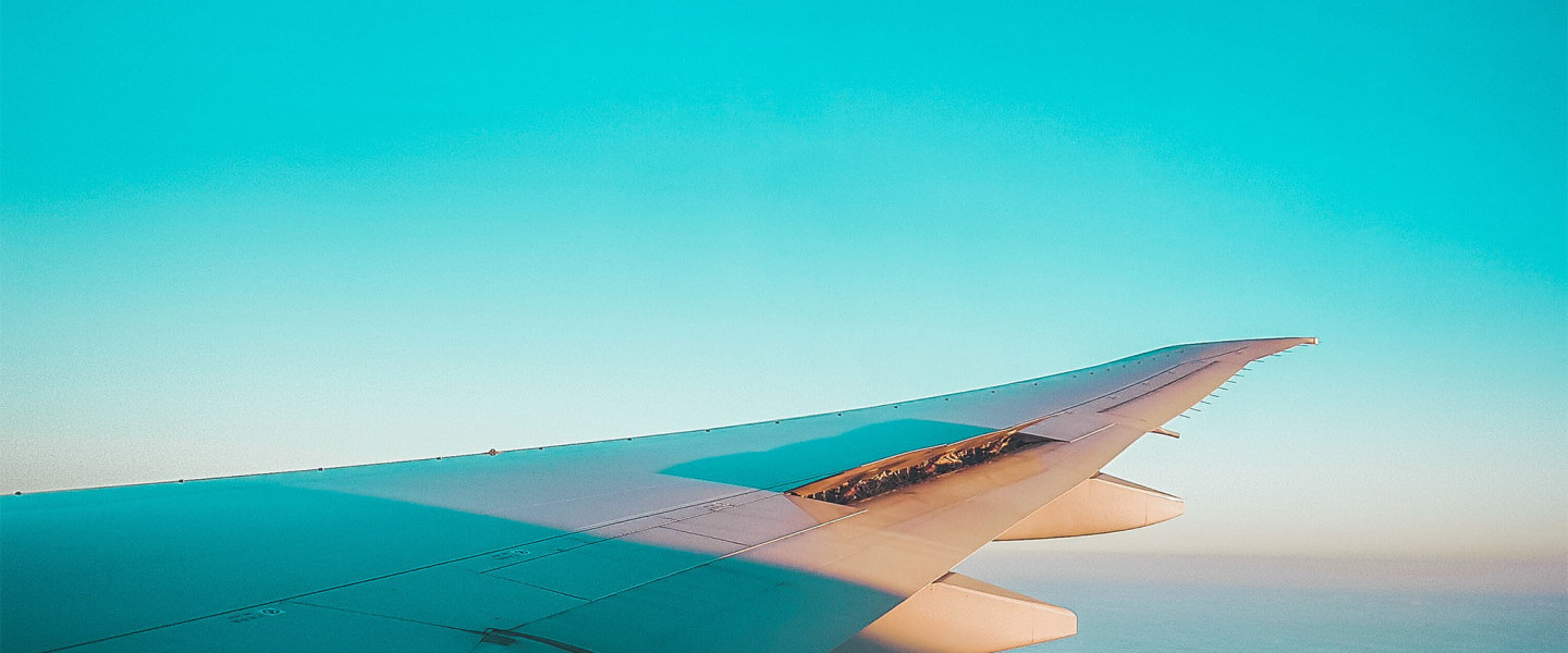 Plane wing through a turquoise sky