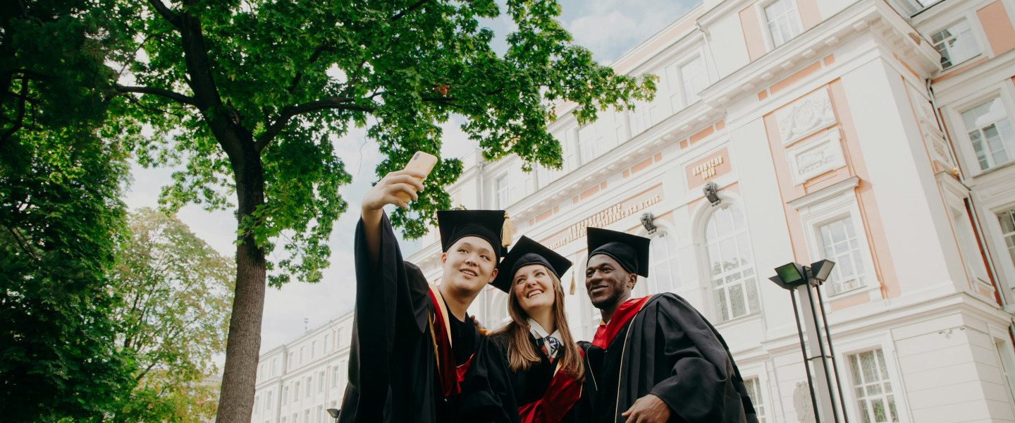 University_graduates_in_cap_and_gown_taking_a_selfie.jpg