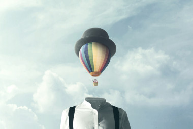 Man_with_hot_air_ballon_as_head_with_blue_sky_and_clouds_behind.jpg