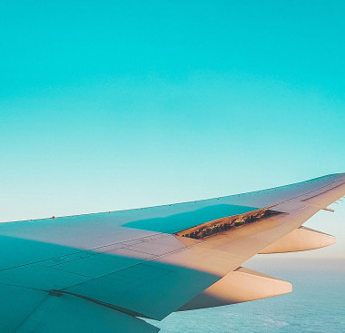 Plane wing through a turquoise sky