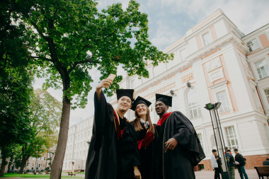 University_graduates_in_cap_and_gown_taking_a_selfie.jpg